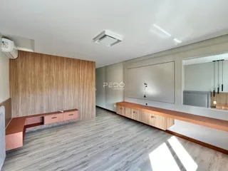 Ambiente interno moderno com paredes de ripas de madeira e piso claro.