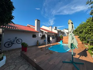 Vista da fachada de uma casa com piscina e deck no Brasil.