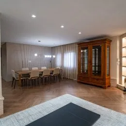 Quarto com piso de madeira e cortinas claras.