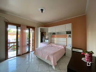 Quarto com portas de madeira que dão acesso a uma varanda.