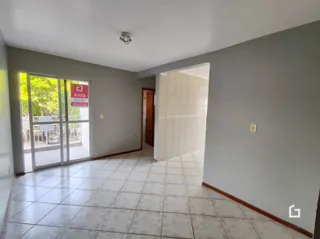 A foto mostra um corredor interno com piso de cerâmica claro.
