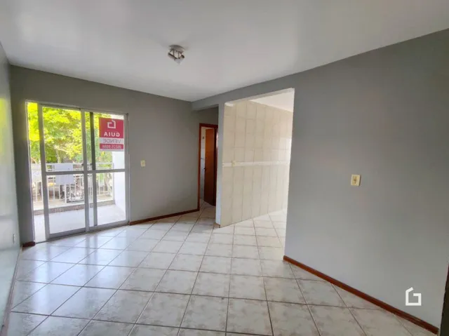 A foto mostra um corredor interno com piso de cerâmica claro.