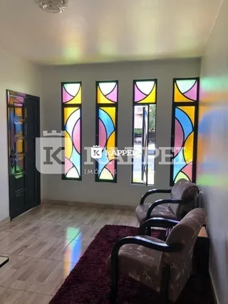 Sala de estar com piso de madeira e decoração de parede colorida.