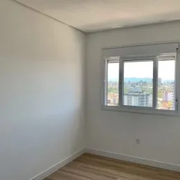 Foto de uma parede branca e piso de madeira em um interior.
