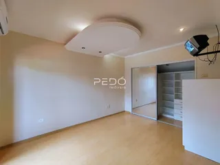 Sala de estar com piso de madeira clara e teto rebaixado.