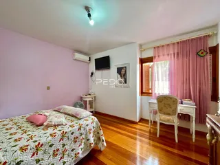 Quarto com piso de madeira e paredes rosa na Lajeado, Brasil.
