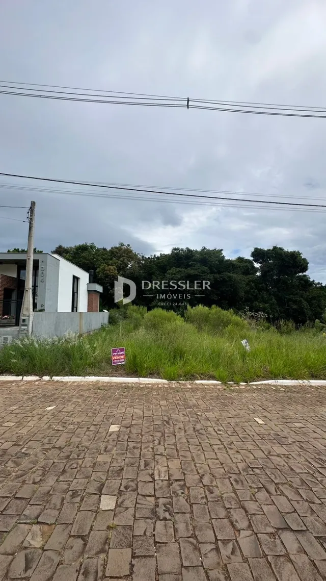 Vista da fachada de uma residência em Lajeado, Brasil, com vegetação ao fundo.