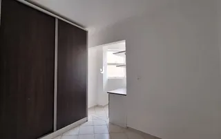 Interior de um corredor com paredes brancas e painéis escuros.