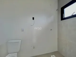 Foto de um banheiro com paredes brancas e piso de cerâmica.