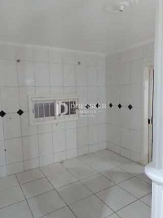 Interior de um cômodo com piso e paredes brancas.