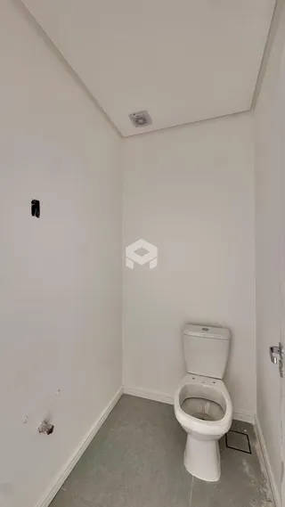 Hall de entrada com paredes brancas e vaso sanitário.