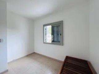 Interior de um cômodo com paredes brancas e piso de cerâmica claro.