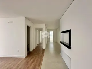 Corredor interno de uma residência com piso de madeira.