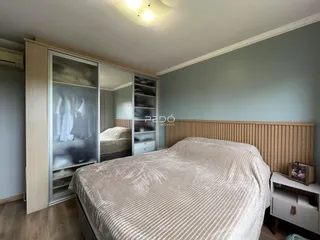 Quarto com cama e armários em um ambiente claro.