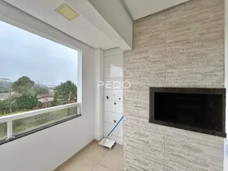 Vista de uma janela de uma área interna com parede texturizada.