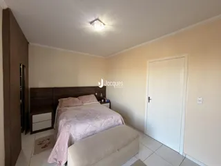 Quarto com cama e cabeceira de madeira.