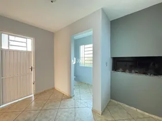 Interior de uma sala com piso de cerâmica e lareira em Lajeado.