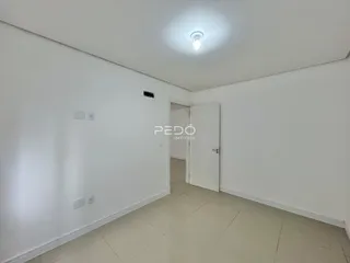 Corredor interno de uma residência com paredes brancas e piso de cerâmica.