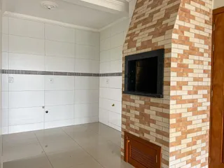 Hall de entrada com piso claro e parede de tijolos aparentes.