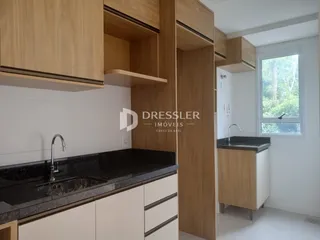 Vista da cozinha com armários de madeira e bancada escura.