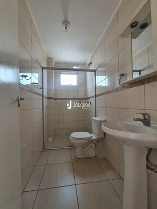 Corredor interno com paredes revestidas de azulejos brancos.
