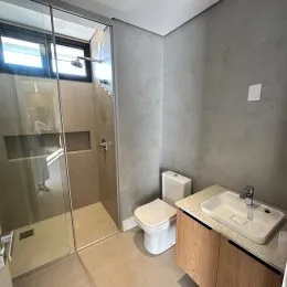 Foto de um corredor interno com um vaso sanitário branco.