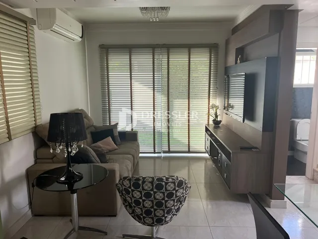 Sala de estar com sofá e janela em um imóvel no Brasil.