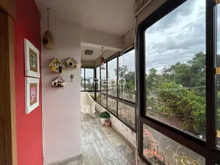 Hall de entrada com parede vermelha e grandes janelas que dão vista para o exterior.