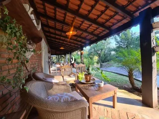 Uma área externa coberta com mobiliário de vime e vegetação.