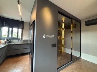 Interior de uma cozinha moderna com acesso a um closet de vidro.