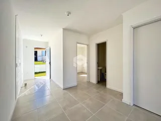 Hall de entrada com piso de cerâmica e paredes brancas.