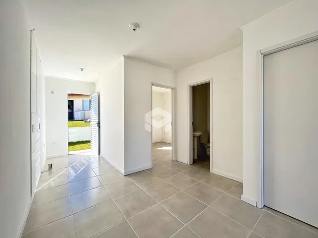 Hall de entrada com piso de cerâmica e paredes brancas.
