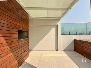 Fachada externa de uma residência com revestimento de madeira e piso de concreto.