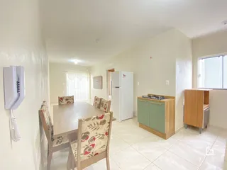 Uma sala de jantar clara com mesa e cadeiras em um apartamento.