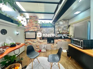 Cozinha com revestimento de tijolos aparentes e piso de madeira.