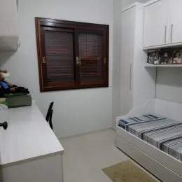 Foto de um ambiente interno com armários brancos e painel de madeira.