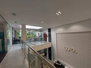 Hall de entrada com escada e guarda-corpo de vidro.