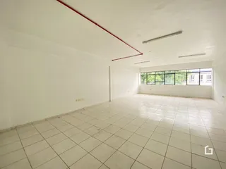 Ambiente interno de uma sala com piso de cerâmica e grandes janelas.