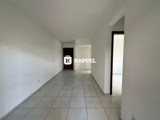 Corredor interno com paredes brancas e piso de cerâmica claro.