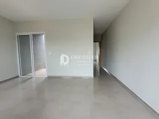 Hall de entrada com piso de cerâmica e paredes brancas.