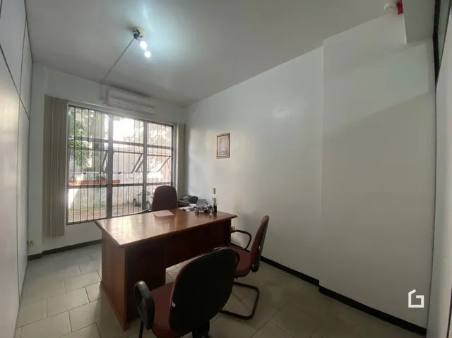 Ambiente interno de uma sala com janela e móveis de madeira.
