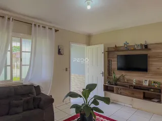 Sala de estar com janela e porta de entrada em imóvel no Brasil.