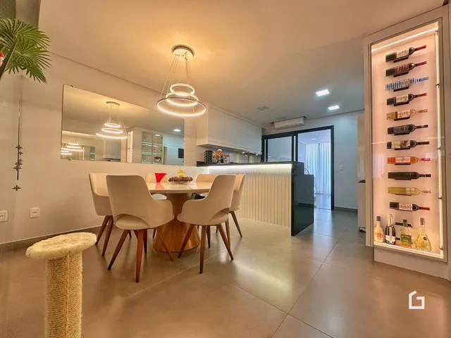 Imagem de uma sala de jantar moderna com iluminação suspensa em um imóvel no Brasil.