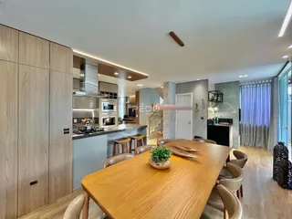 Imagem de uma sala de estar e cozinha moderna com móveis de madeira em um imóvel.