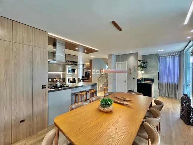 Imagem de uma sala de estar e cozinha moderna com móveis de madeira em um imóvel.