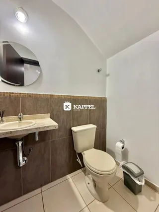 Foto de um banheiro com pia e vaso sanitário revestido de azulejos.