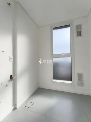 Interior de um ambiente com paredes brancas e piso claro.