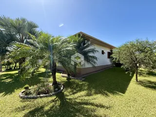 Fachada de uma residência em Lajeado, Brasil, com jardim verde e vegetação exuberante.
