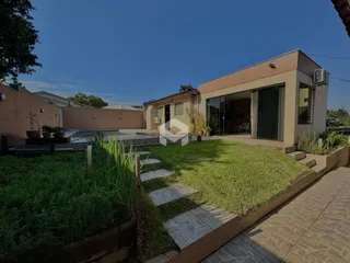Foto da fachada de uma residência com jardim e piscina no Brasil.
