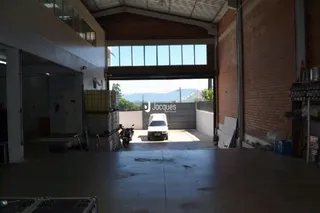 Área externa de concreto com acesso a uma estrutura.